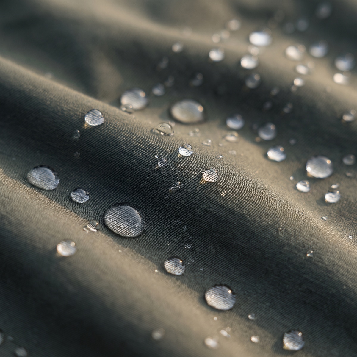 Wassertropfen perlen auf dem wasserabweisenden Gewebe ab